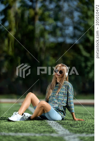 blonde athletic girl sitting on the football field blonde athletic girl sitting on the football field 105010472