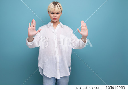 strict fashionable woman with a bob haircut dressed in a white shirt shows a stop gesture 105010963