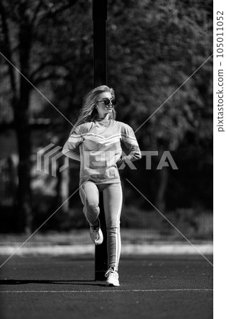 sports girl blonde stands on the basketball court black and white 105011052