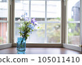 Flowers in a vase by the window 105011410