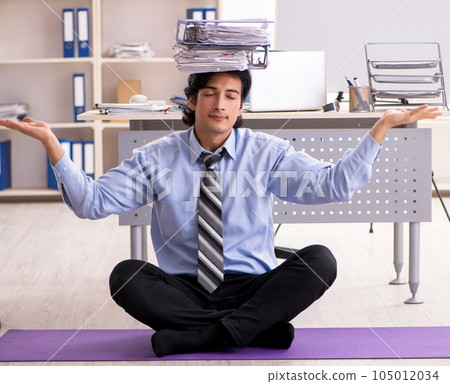 Young handsome male employee doing exercises in the office Young handsome male employee doing exercises in the office 105012034