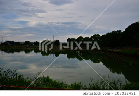 Forest and sky reflected on the surface of the water Forest and sky reflected on the surface of the water 105012451