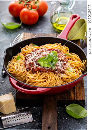 Spaghetti Bolognese in a cast iron pan 105012645
