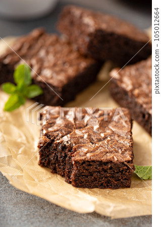 Freshly baked brownies on a parchment paper Freshly baked brownies on a parchment paper 105012664
