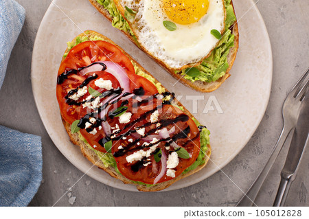Avocado toasts with fried egg and heirloom tomatoes Avocado toasts with fried egg and heirloom tomatoes 105012828