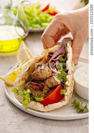 Chicken souvlaki with fresh vegetables on a flatbread 105012886