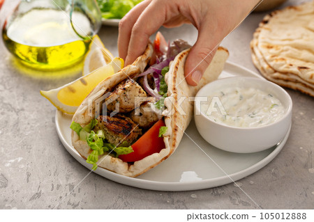 Chicken souvlaki with fresh vegetables on a flatbread 105012888