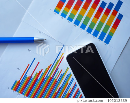 Graph and smartphone on the table 105012889