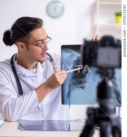 Young male doctor radiologist recording video for his blog 105013242