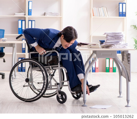 Young male employee in wheelchair working in the office 105013262