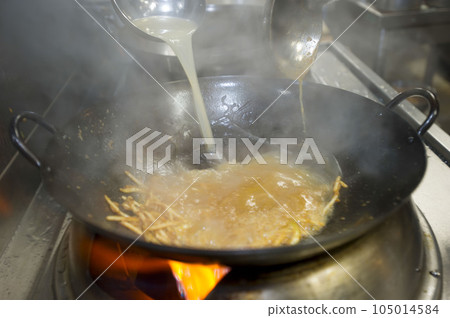 Cooking with heat in a wok Cooking with heat in a wok 105014584