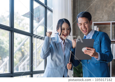 Two asian businesspleplo celebrate with laptop, success happy pose, E-commerce, get good news on laptop. internet technology, or startup small business concept 105017182