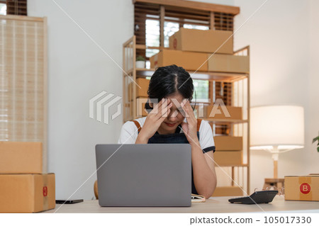 Small online business owner Asian woman wearing apron stressed headache taking Less sales, returned products at home Small online business owner Asian woman wearing apron stressed headache taking Less sales, returned products at home 105017330