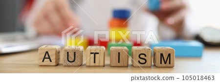 Word autism assembled from wooden blocks close-up and psychiatrist doctor with colored blocks. 105018463