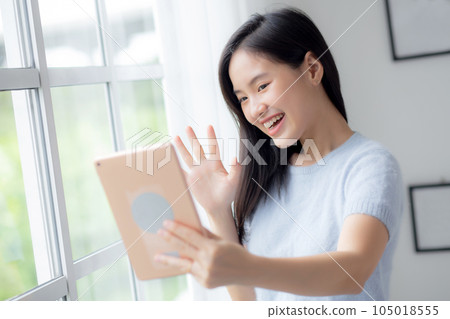 Happiness young asian woman video call with digital tablet in the living room at home. Happiness young asian woman video call with digital tablet in the living room at home. 105018555
