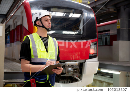 Young engineer man or worker checking electric train for planning maintenance and writing document. 105018807