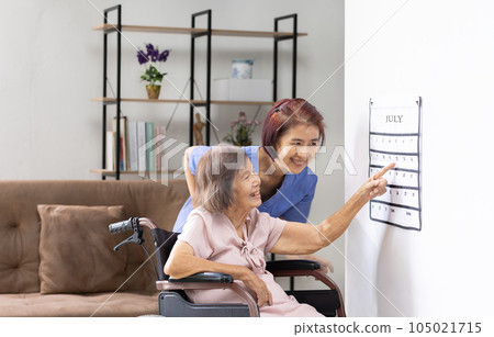 Asian senior woman read a calendar therapy exercises used by dementia patients with caregiver. 105021715