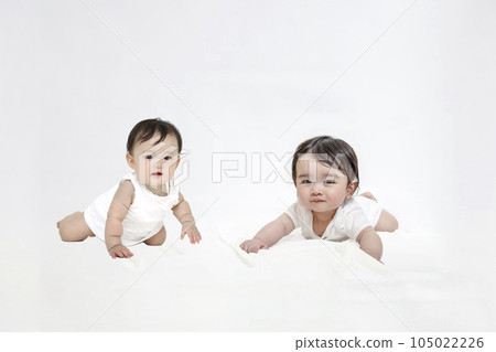 Two babies crawling looking at the camera 105022226