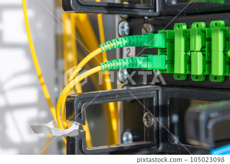 Fiber Optic cables connected to an optic ports - data switch in internet data center Fiber Optic cables connected to an optic ports - data switch in internet data center 105023098