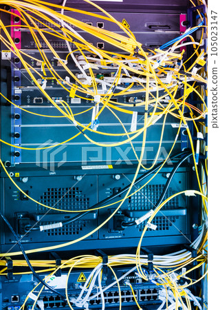 yellow fiber optic cables plugged in network switch 105023147