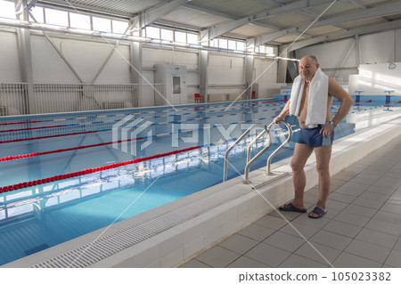 An elderly man is actively engaged in swimming and sports in the pool in a retired sports complex. An elderly man is actively engaged in swimming and sports in the pool in a retired sports complex. 105023382