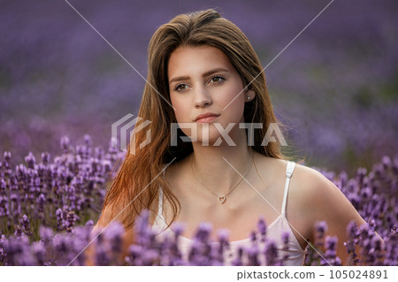 Closeup portrait of beautiful brunette girl posing in lavender field. 105024891
