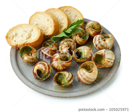 plate of baked escargot snails filled with parsley and garlic butter plate of baked escargot snails filled with parsley and garlic butter 105025971