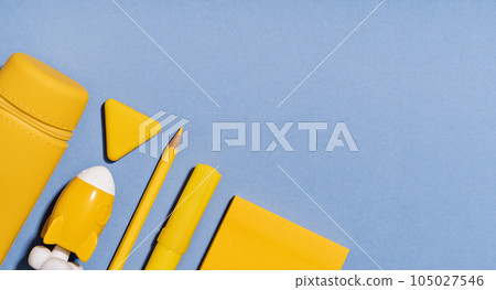 Assorted office and school yellow stationery on lilac blue. copy space for back to school or education craft office work concept. Bright Yellow rocket. Achievement and success. Top view 105027546