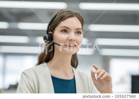 A smiling foreign woman wearing a headset and speaking A smiling foreign woman wearing a headset and speaking 105027560