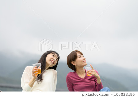 兩個女人在戶外喝啤酒 兩個女人在戶外喝啤酒 105028196