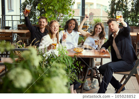 Beautiful, cheerful young people, colleagues, business people meeting after work at restaurant, pub, cafe. Good time 105028852