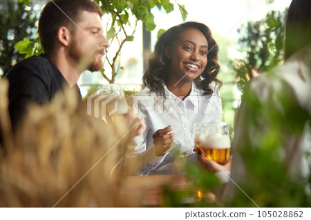 Friends, co-workers meeting together after work, celebrating projects, spending lovely time together , drinking beer at pub, cafe 105028862