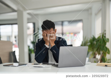 Overwork and deadline concept. Stressed asian businessman working on laptop, touching and massaging temples. Mature male having headache, reducing stress Overwork and deadline concept. Stressed asian businessman working on laptop, touching and massaging temples. Mature male having headache, reducing stress 105028972