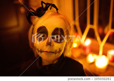 Little child in scary skeleton costume at Halloween celebration party. The child is ready for trick or treat on Halloween night. The kid scares. 105030261
