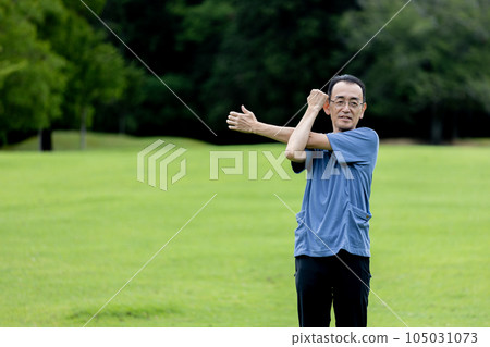 Mature man exercising on the lawn Mature man exercising on the lawn 105031073