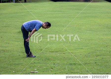 Mature man exercising on the lawn Mature man exercising on the lawn 105031077