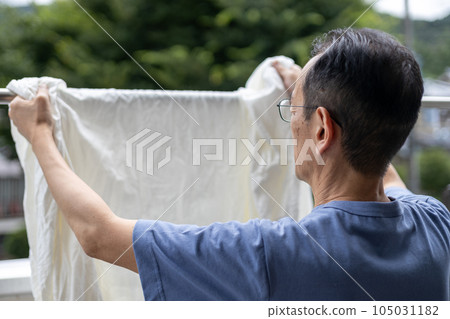 Middle-aged man drying the laundry 105031182