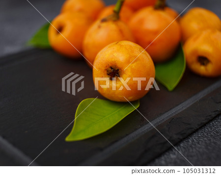 Loquat Medlar fruit isolated on dark table background Loquat Medlar fruit isolated on dark table background 105031312