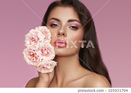 Beautiful young woman with a rose flower 105031704
