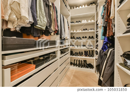 a walk - in closet with white shelvings and lots of clothes hanging on the wall behind it, a walk - in closet with white shelvings and lots of clothes hanging on the wall behind it, 105031850