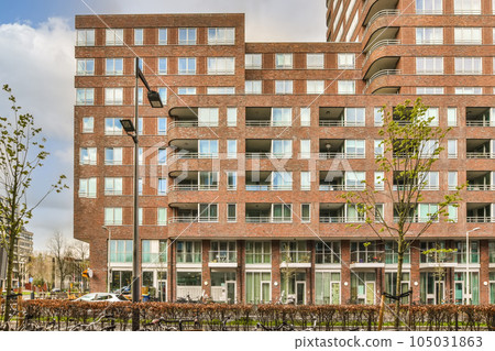 a brick building with many windows and bales on the sides, in an urban area that is well maintained a brick building with many windows and bales on the sides, in an urban area that is well maintained 105031863