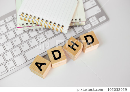 Abbreviation of ADHD on wood cube block with computer keyboard and note book on white table 105032959