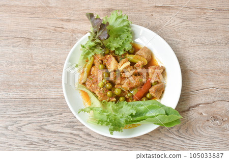 spicy fried pork bone with curry and basil leaf with fresh vegetable on plate spicy fried pork bone with curry and basil leaf with fresh vegetable on plate 105033887