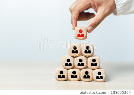 Hand holding select wooden cubes with red human icons Hand holding select wooden cubes with red human icons 105035264