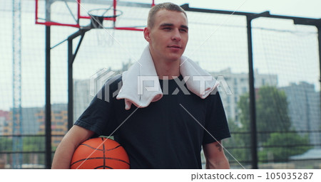 Portrait of man basketball player with ball on play ground looking at camera. Healthy lifestyle and sport concept. Portrait of man basketball player with ball on play ground looking at camera. Healthy lifestyle and sport concept. 105035287