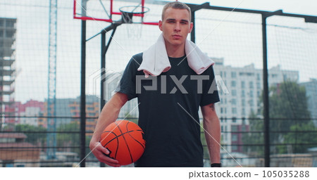 Man basketball player with ball on play ground looking at camera. Healthy lifestyle and sport concept. Man basketball player with ball on play ground looking at camera. Healthy lifestyle and sport concept. 105035288