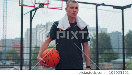Man basketball player with ball on play ground looking at camera. Healthy lifestyle and sport concept. 105035301