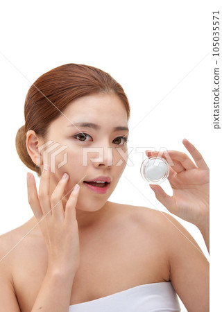 beautiful young woman with clean skin and moisturizing cream 105035571