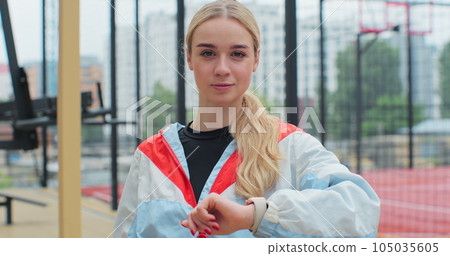 Young fitness woman looking at smartwatch outdoors athlete training equipment app. Healthy lifestyle concept. Young fitness woman looking at smartwatch outdoors athlete training equipment app. Healthy lifestyle concept. 105035605