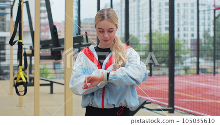 Woman stopped workout to check indicators on her fitness watch. Healthy lifestyle concept. 105035610